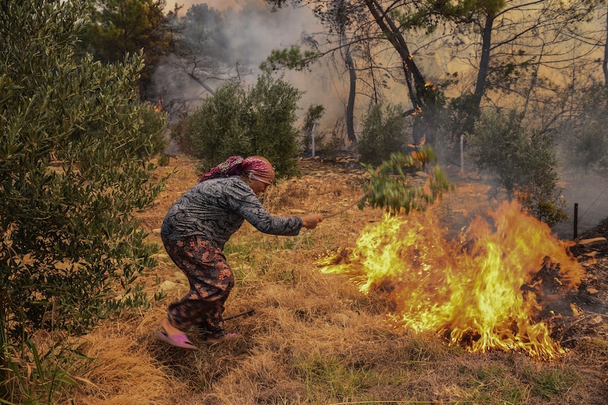 Женщина пытается остановить массовый пожар в селе Какарлар