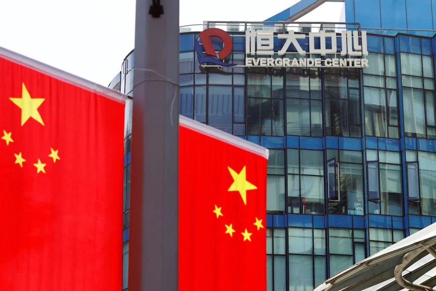 Китайские флаги возле логотипа Evergrande Center в Шанхае, Китай, 24 сентября 2021 года.