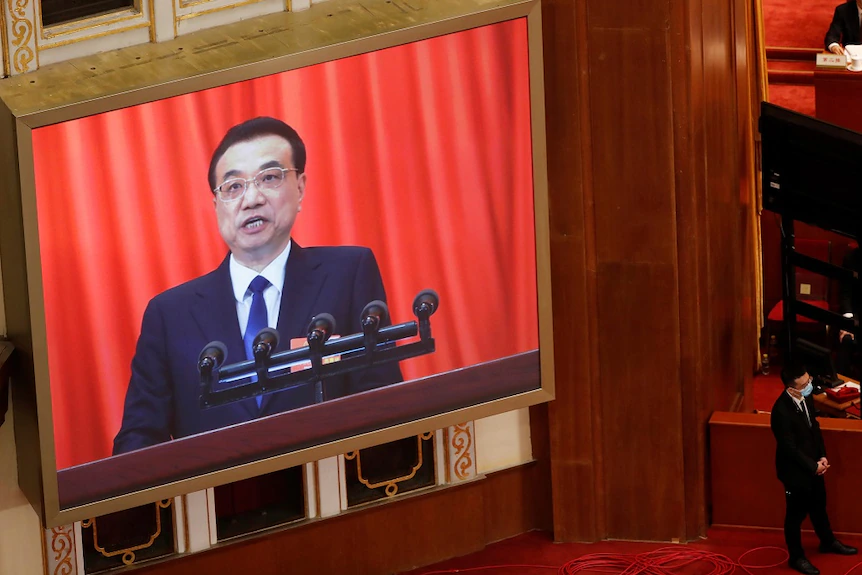 Премьер-министр Китая Ли Кэцян появляется на экране во время выступления на открытии сессии Всекитайского собрания народных представителей.