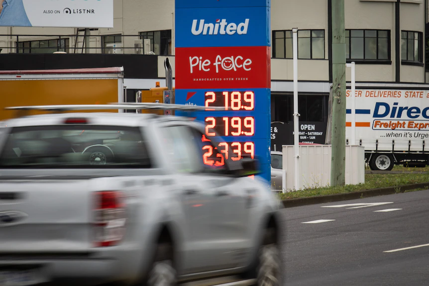 Незаметная машина едет по шоссе и за ней показывает цены на бензин