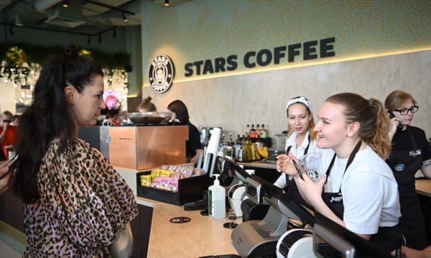 Клиент разговаривает с баристой за стойкой Stars Café, декор которой очень похож на американскую сеть Starbucks.