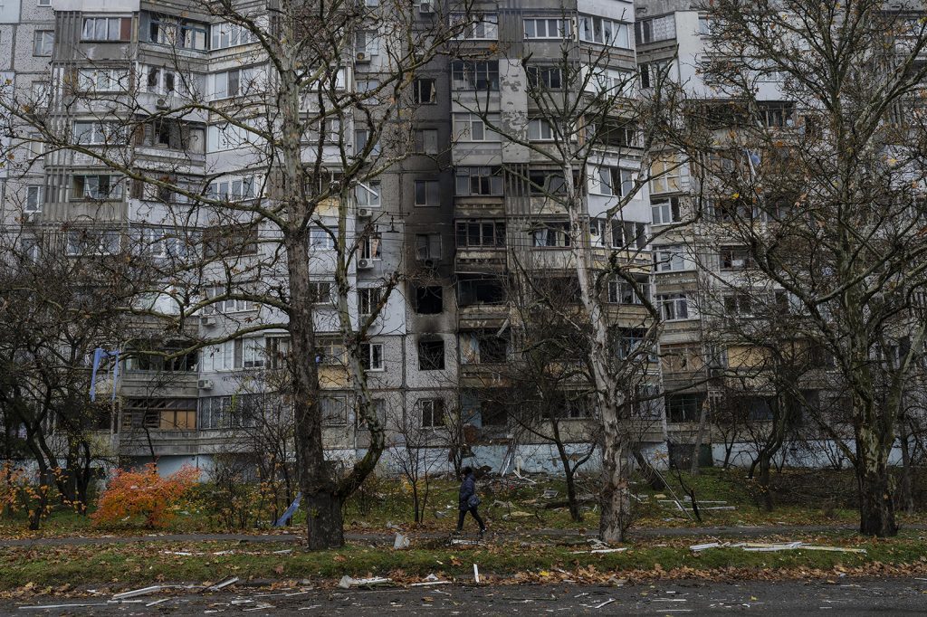 A woman walks past a recently damaged building due to a Russian strike in Kherson, southern Ukraine, on November 25.